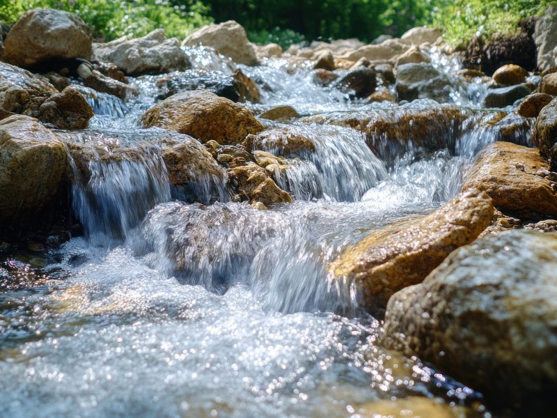 Clear mountain stream cascading over rocks. Use Nature background