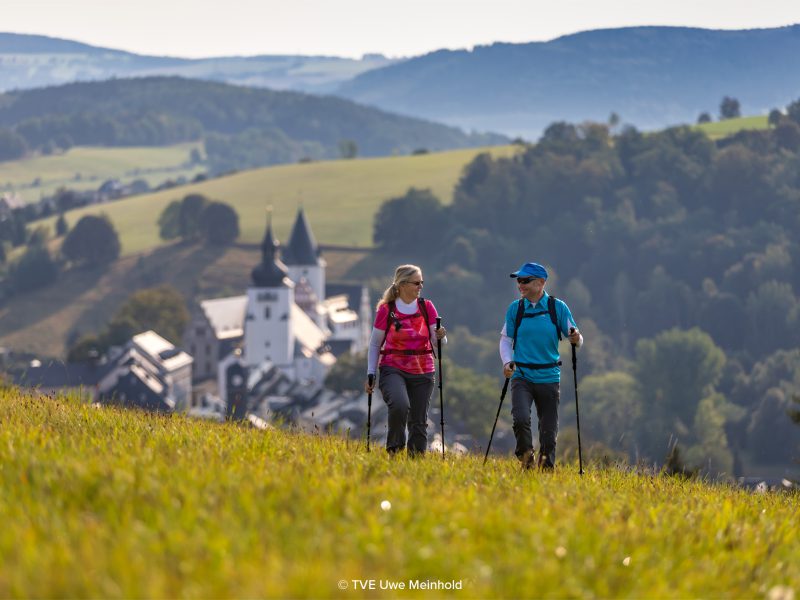 12.09.2020 - Schwarzenberg: Tourismusverband Erzgebirge, Wandern um Schwarzenberg, Hartmut und Kathrin Haase wandern auf einem Feld vor der Kulisse der Altstadt mit Schloﬂ und Kirche.  Foto: Uwe Meinhold 
Copyright Uwe Meinhold